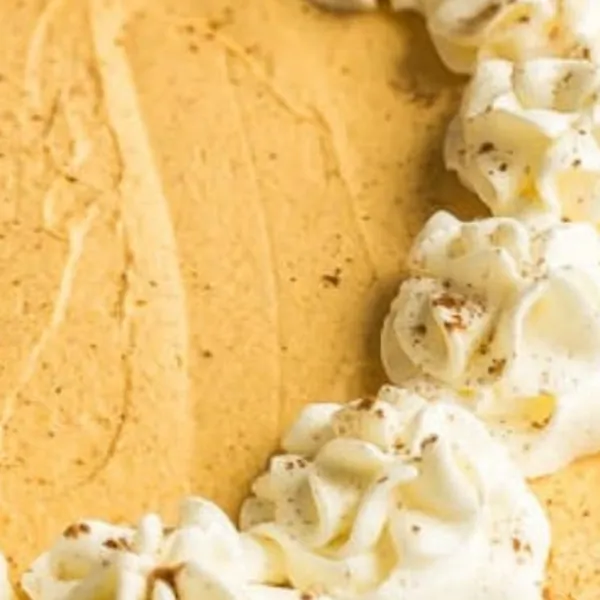 Close-up showing the smooth spiced pumpkin filling and buttery graham crust
