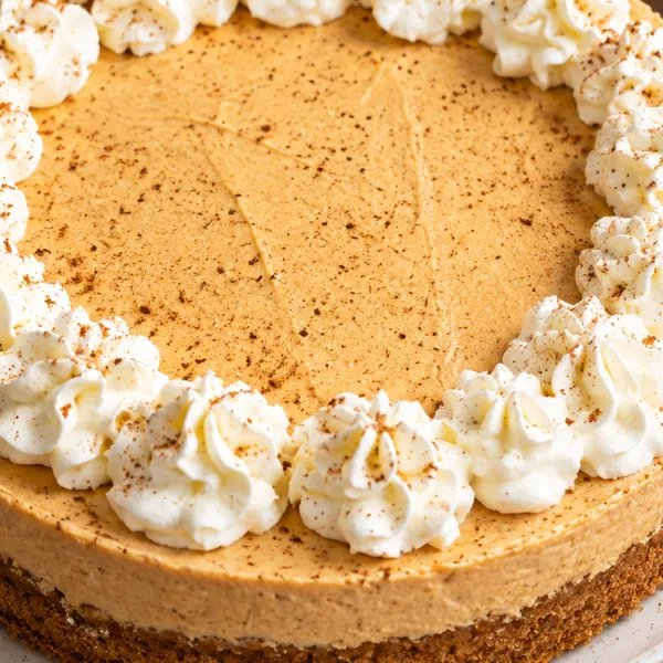 Close-up of the smooth pumpkin filling and piped cream rosettes on the edge